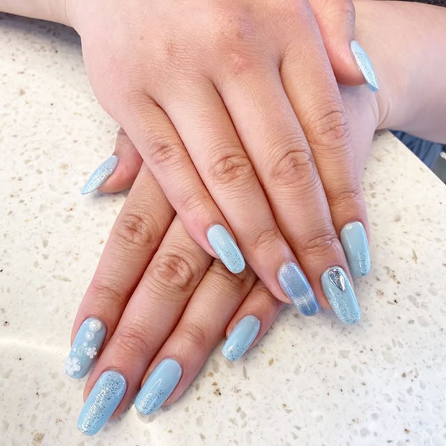 Soft blue Japanese gel nails with glitter and floral accents at Mega Japanese Nail, Japanese gel nails NYC